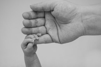 Hände der Mutter und ihrem Kind